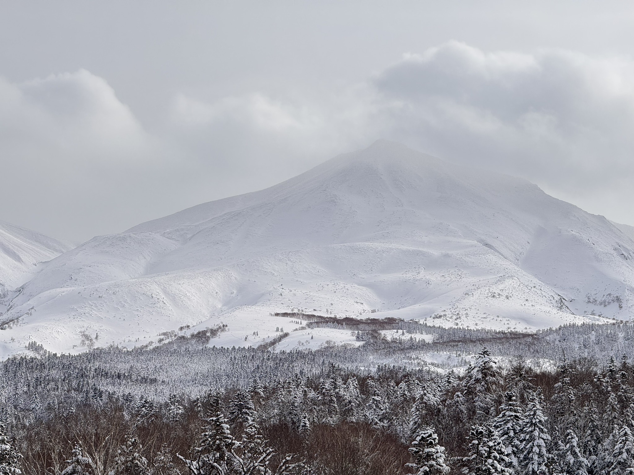 Snow-covered mountain and low cloud conditions in Japan.